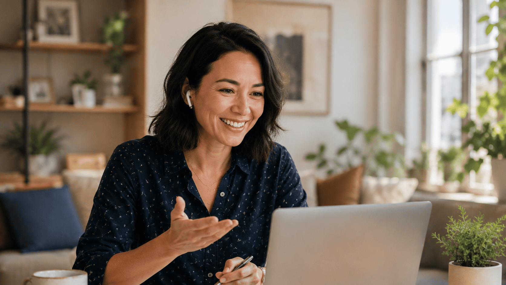 Smiling woman with an earbud speaking in a live online English lesson at home